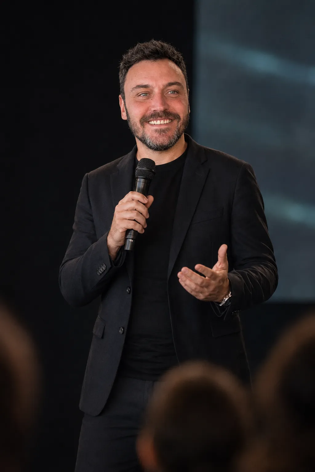 Rodrigo Feldman falando ao microfone em um palco